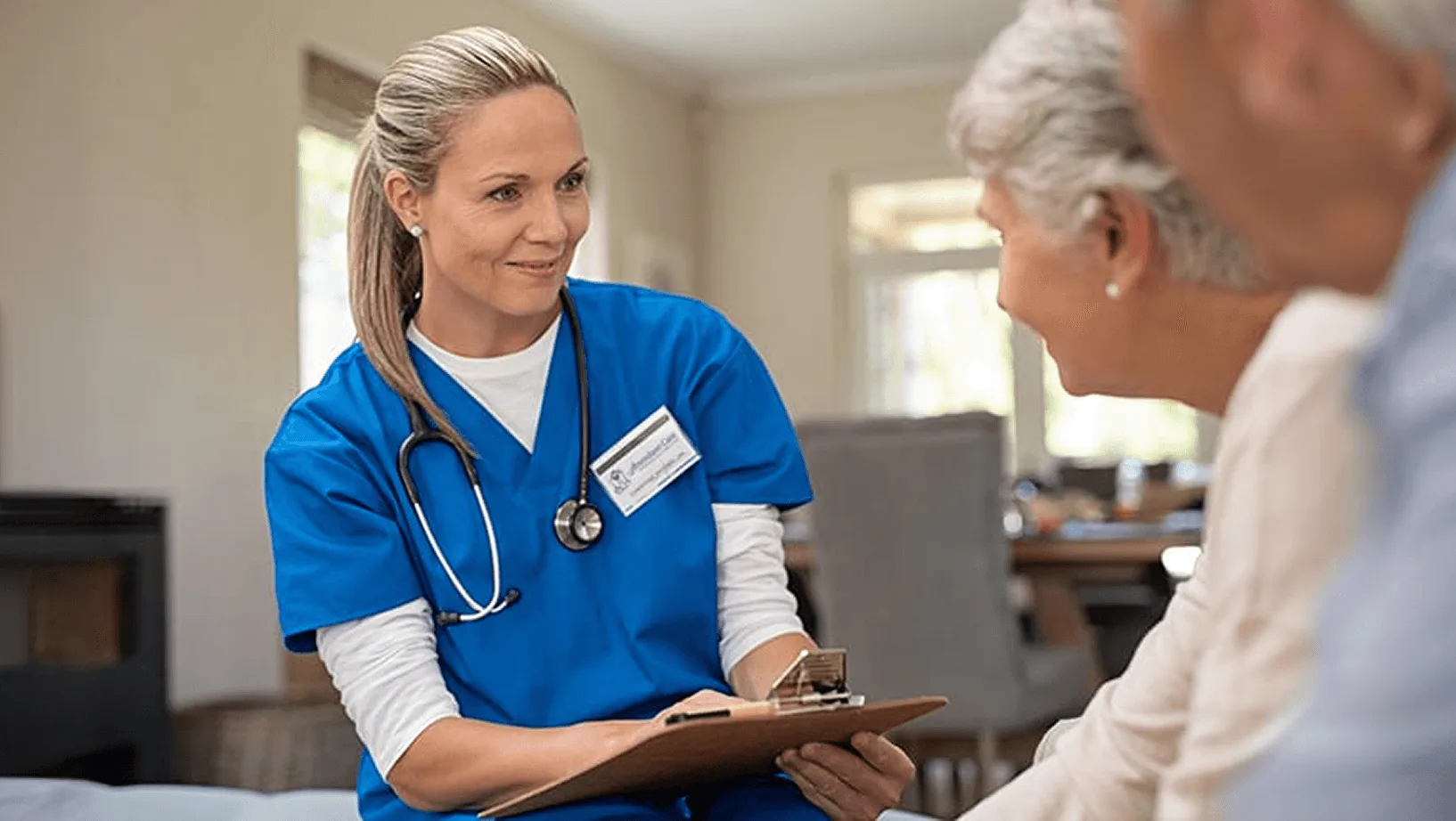 Healthcare professional speaking with elderly patients during a home care consultation